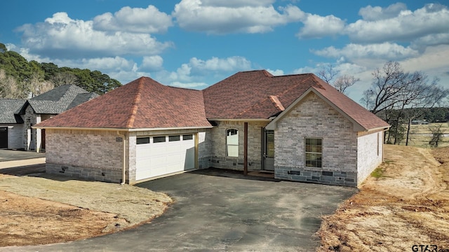 view of front facade featuring an attached garage, brick siding, driveway, and a shingled roof