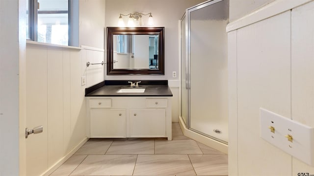 bathroom featuring vanity and a shower with door