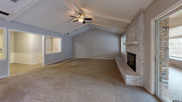 unfurnished living room with ceiling fan, vaulted ceiling with beams, light colored carpet, and a fireplace