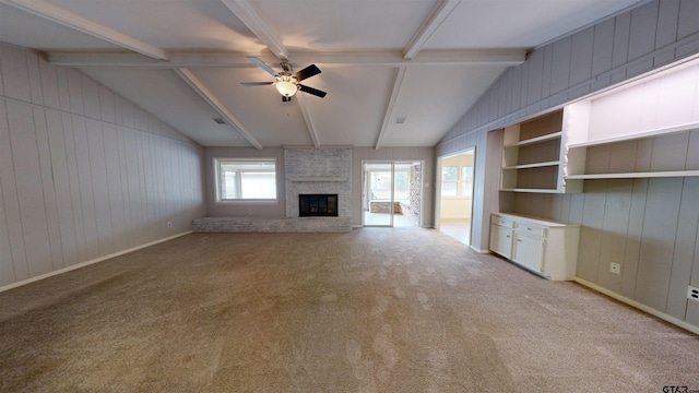 unfurnished living room featuring lofted ceiling with beams, a brick fireplace, light colored carpet, and ceiling fan