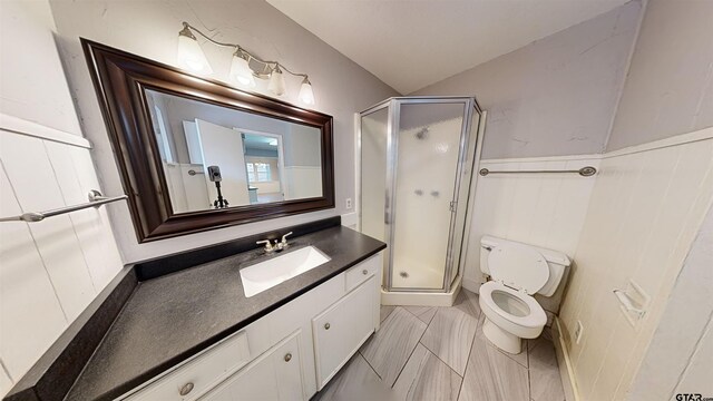 bathroom with vanity, toilet, and a shower with door