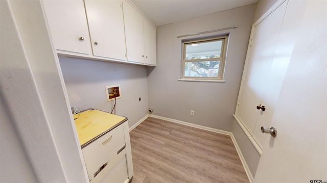 clothes washing area featuring cabinets, hookup for an electric dryer, washer hookup, and light hardwood / wood-style flooring