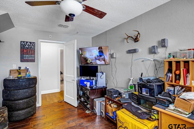 interior space featuring a textured ceiling, wood finished floors, and visible vents
