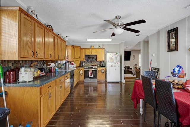 kitchen featuring a ceiling fan, stainless steel electric range oven, backsplash, black dishwasher, and freestanding refrigerator