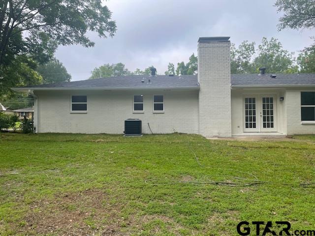 110 Alpine Dr, Tyler, TX 75701 - back of house featuring french doors, a chimney, a lawn, and brick siding