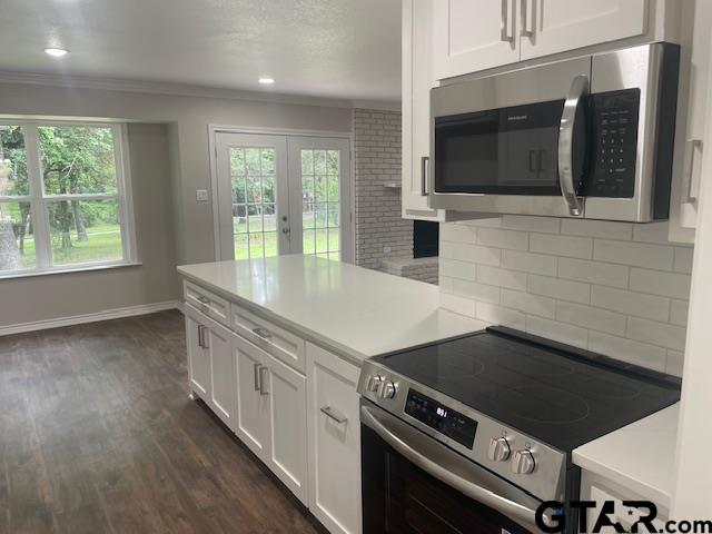 110 Alpine Dr, Tyler, TX 75701 - kitchen featuring stainless steel appliances, white cabinets, backsplash, french doors, and ornamental molding