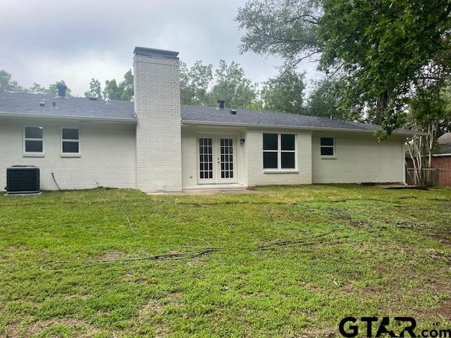 110 Alpine Dr, Tyler, TX 75701 - back of house featuring french doors, a chimney, a lawn, and brick siding