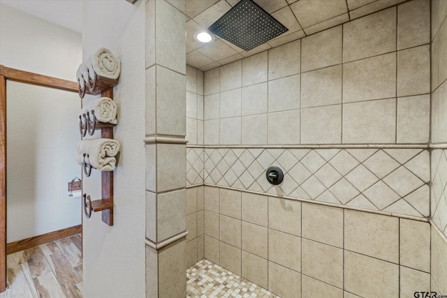 bathroom with wood-type flooring and tiled shower