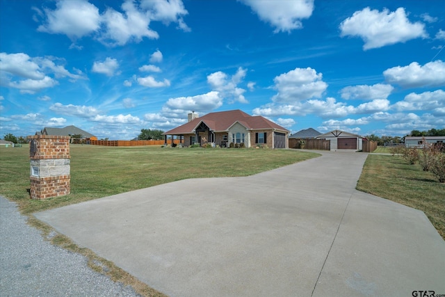 view of front of home with an outbuilding, a front yard, and a garage