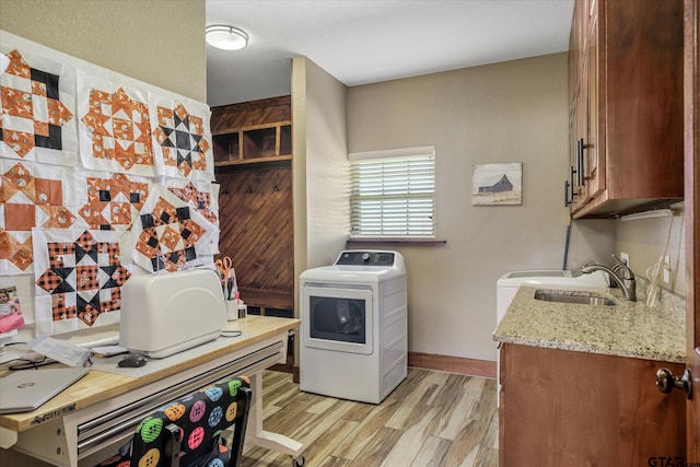 washroom with washer / clothes dryer, light hardwood / wood-style flooring, cabinets, and sink