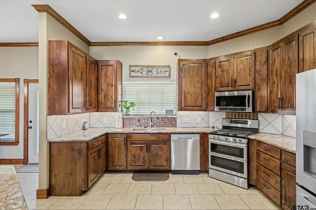 kitchen with light stone countertops, crown molding, appliances with stainless steel finishes, and tasteful backsplash