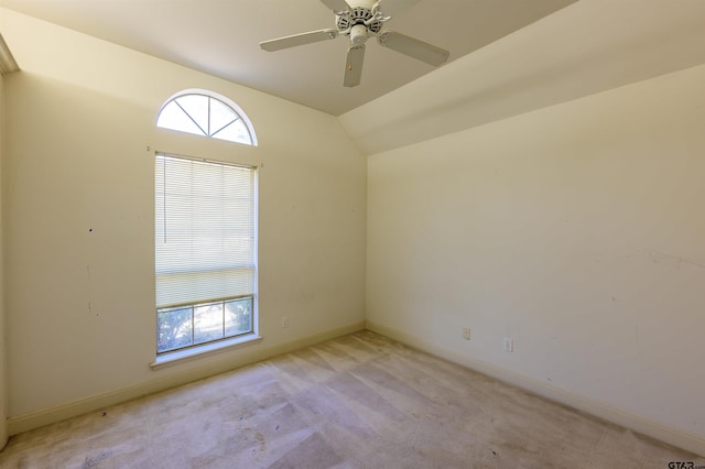 spare room with light carpet, ceiling fan, and vaulted ceiling