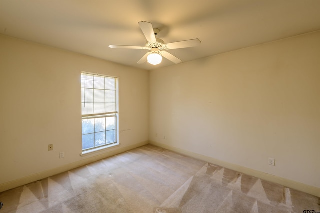 empty room featuring ceiling fan and light carpet