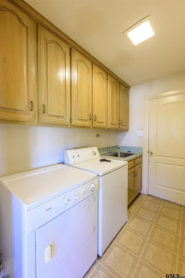 washroom featuring cabinets, independent washer and dryer, and sink