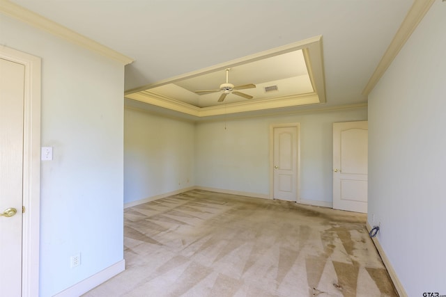 carpeted empty room with a raised ceiling, ceiling fan, and crown molding