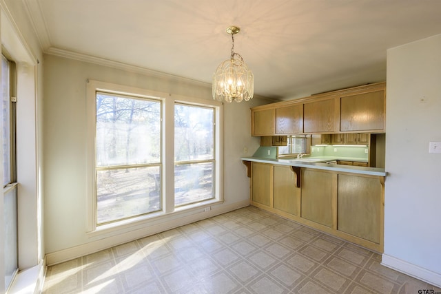 kitchen featuring kitchen peninsula, light brown cabinetry, crown molding, a notable chandelier, and hanging light fixtures