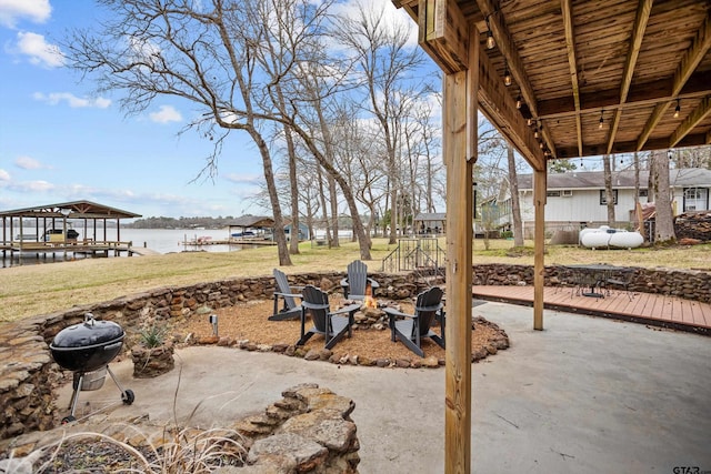 view of patio with area for grilling, a fire pit, and a water view