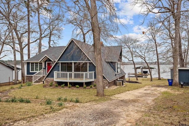 view of front of property with central AC unit, a front yard, and dirt driveway