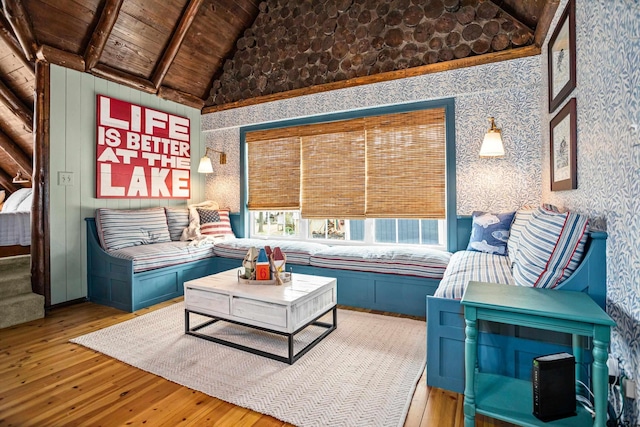 living room with high vaulted ceiling, wallpapered walls, beam ceiling, light wood-style flooring, and wooden ceiling