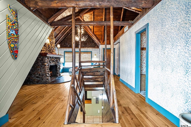 interior space with stairway, vaulted ceiling with beams, a fireplace, wood ceiling, and wood-type flooring