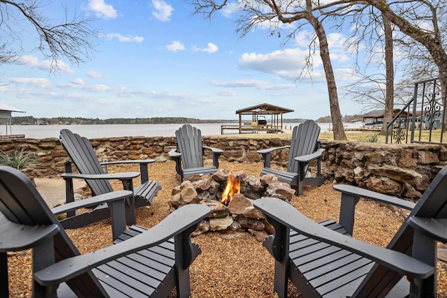 view of patio with a water view and an outdoor fire pit