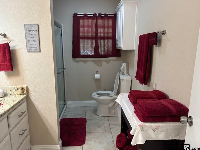 bathroom featuring toilet, an enclosed shower, vanity, and tile patterned flooring