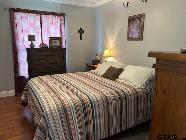 bedroom featuring dark hardwood / wood-style flooring and crown molding