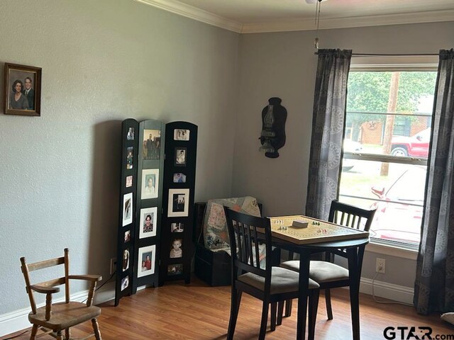 dining area featuring hardwood / wood-style flooring and crown molding