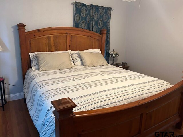 bedroom with dark hardwood / wood-style flooring