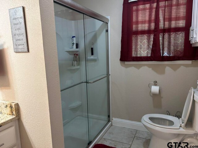 bathroom featuring a shower with shower door, vanity, and toilet