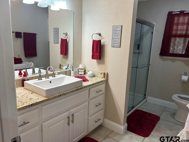 bathroom with toilet, vanity, an enclosed shower, and tile patterned floors