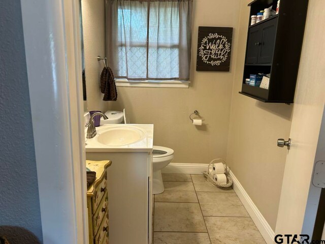 bathroom featuring vanity, tile patterned floors, and toilet