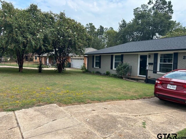 single story home with a garage and a front yard