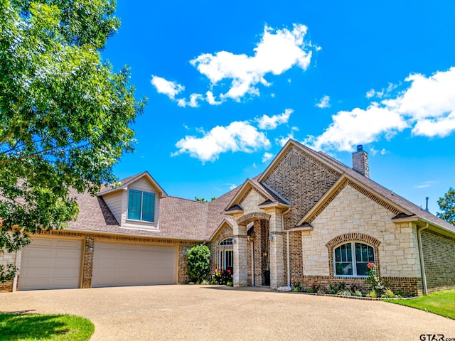 view of front facade featuring brick siding, driveway, a garage, and roof with shingles