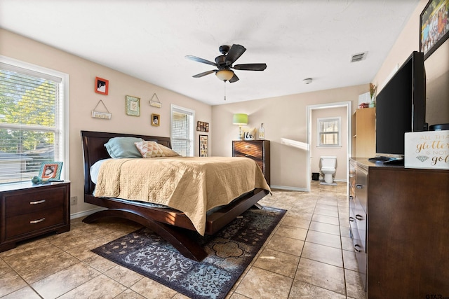 tiled bedroom featuring ensuite bathroom and ceiling fan