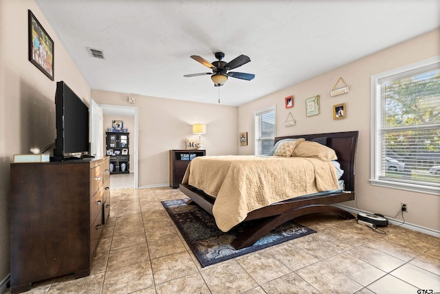 bedroom with ceiling fan, light tile patterned floors, and multiple windows