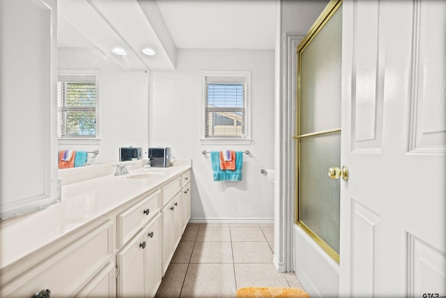 bathroom with tile patterned floors, vanity, and bath / shower combo with glass door