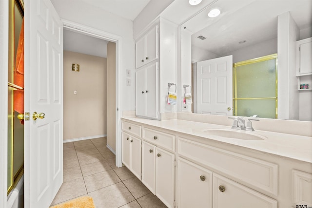 bathroom with tile patterned flooring, vanity, and a shower with door