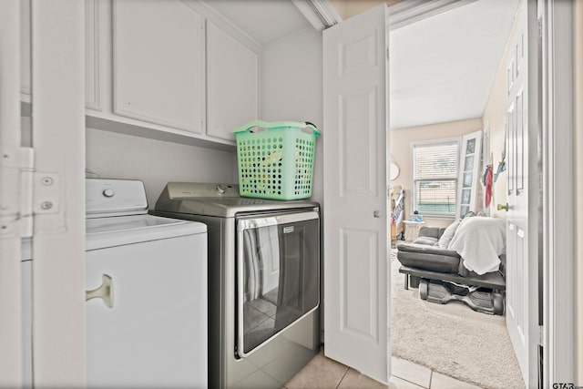 washroom with cabinets, light tile patterned floors, and washer and dryer