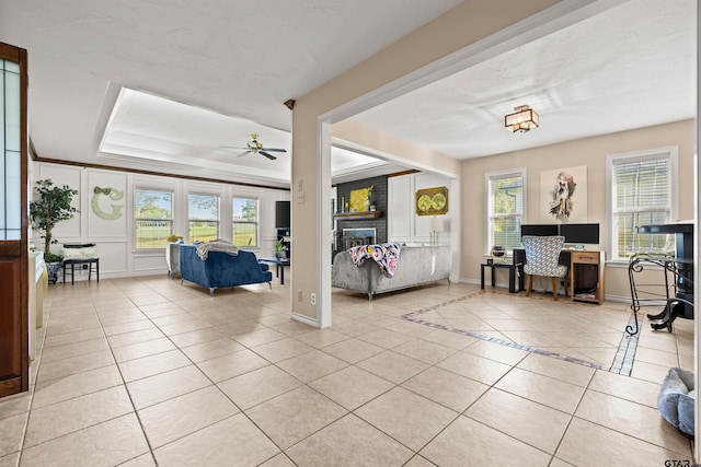 bedroom featuring a raised ceiling, light tile patterned floors, and a brick fireplace