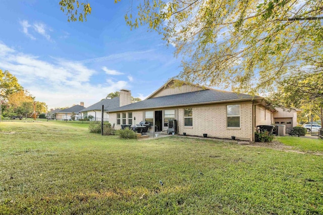 rear view of property featuring a yard and a patio