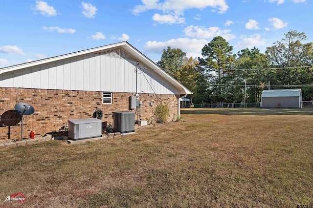 view of home's exterior featuring a yard, brick siding, and central air condition unit