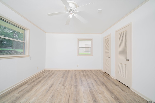 2504 Pounds Ave, Tyler, TX 75701 - unfurnished bedroom featuring crown molding, multiple windows, wood finished floors, two closets, and baseboards
