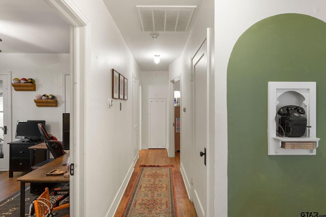 corridor with hardwood / wood-style flooring