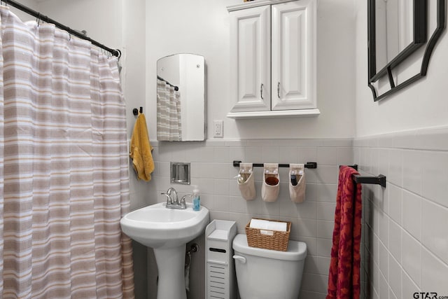 bathroom featuring tile walls, toilet, and a shower with shower curtain