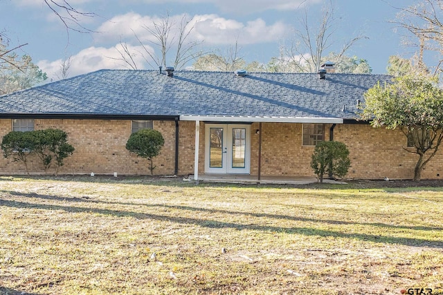 back of property with a lawn and french doors