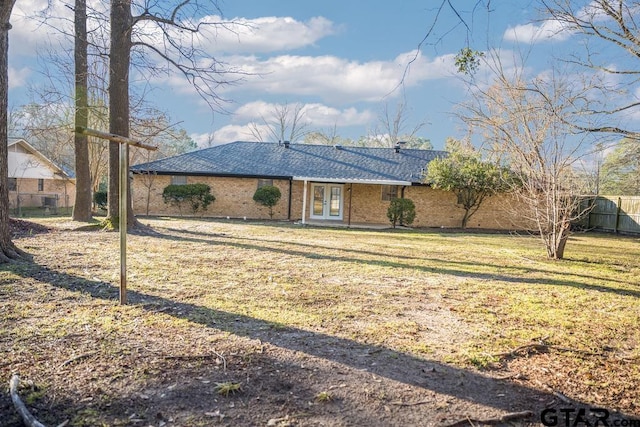 view of front of home with french doors and a front lawn