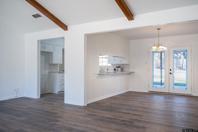 interior space featuring an inviting chandelier, dark hardwood / wood-style flooring, and vaulted ceiling with beams