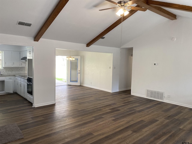 unfurnished living room with ceiling fan with notable chandelier, dark wood-type flooring, and lofted ceiling with beams