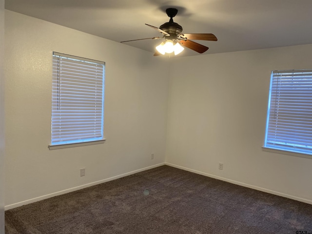 carpeted spare room featuring ceiling fan